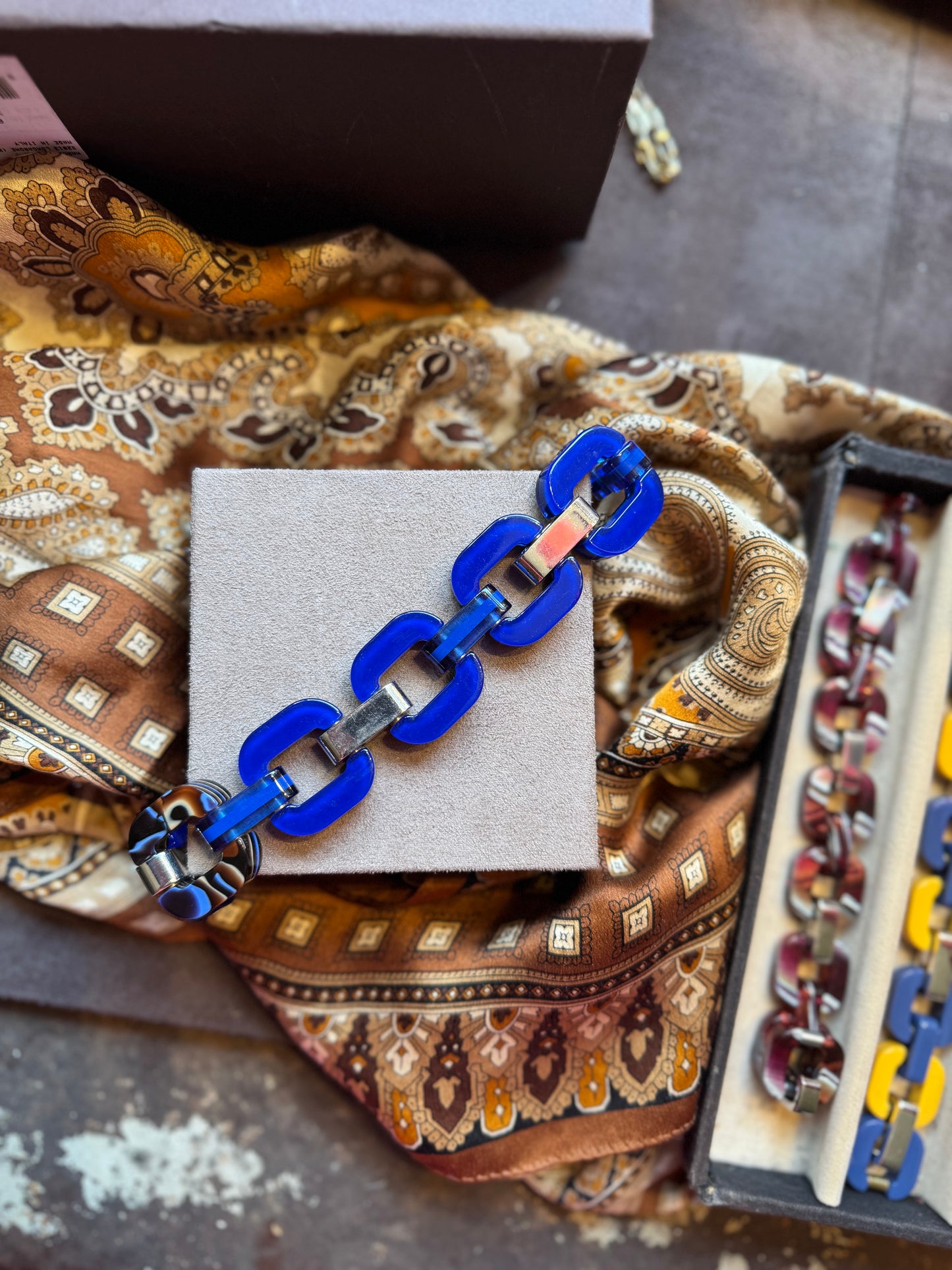 Blue chain bracelet with a patterned link in a tortoise shell style.