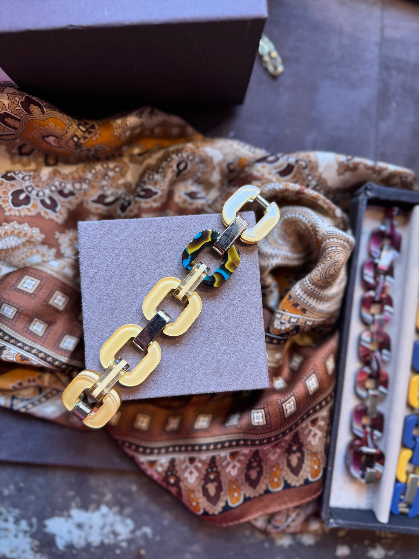 Yellow chain bracelet with patterned link in a tortoise shell style.