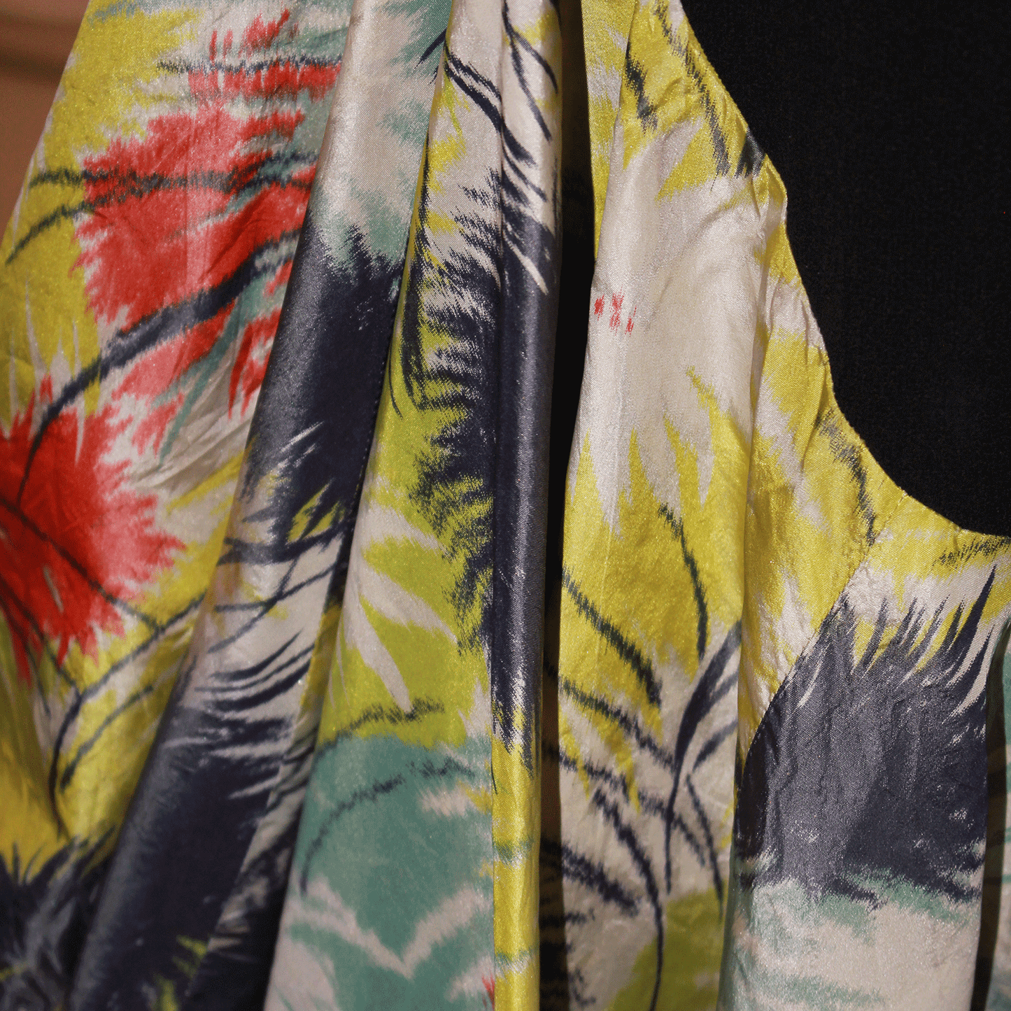 Tropical silk ruffed flounce hem detailing of black evening dress.